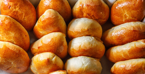 Freshly baked pies lie on a tray. Flat layout. Bread texture.