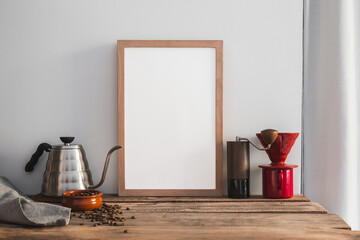 Mock- up frame and home barista brewing set with drip kettle, manual grinder and coffee beans.
