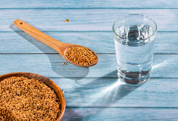 Spoon with fenugreek grains to mix with water - Trigonella foenum-graecum