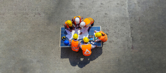 Top view of architectural engineer working on solar panel and his blueprints with Solar photovoltaic equipment on construction site. meeting, discussing, designing, planing, Clean energy concept