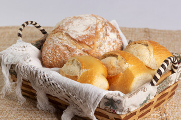 Closeup of basket with one Italian bread and three baguettes or french breads. 