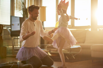 A little ballerina practicing a ballet move at a training at home with a help of her father. Family, ballet, training © luckybusiness