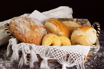 Closeup of basket with one Italian bread and three baguettes or french breads and two chipas or...