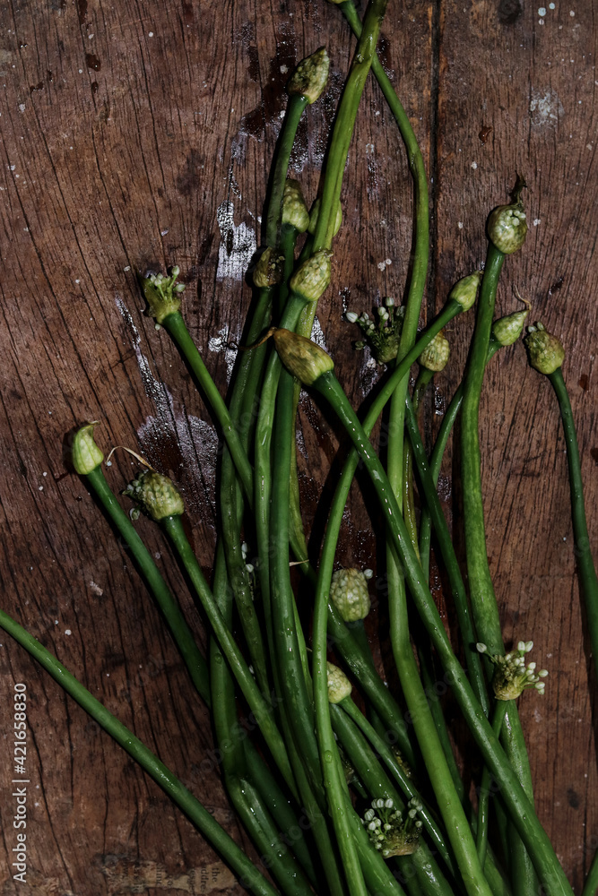 Sticker vertical shot of a green onion bunch on a wooden table