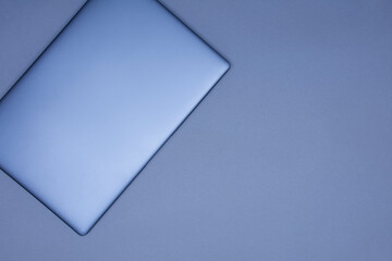 Closed silver laptop on a gray background. Top view.