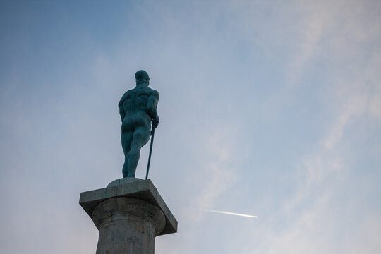Close up on the Victor statue on Kalemegdan fortress, during a sunny sunset afternoon, seen from behind. Also called Viktor Pobednik, Located in Kalemegdan fortress, it's a landmark of the city