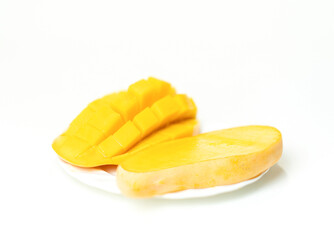Golden mango slices on a white plate.