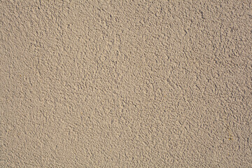 Simple brown background texture in the form of a rough granular coating with putty or plaster on a...