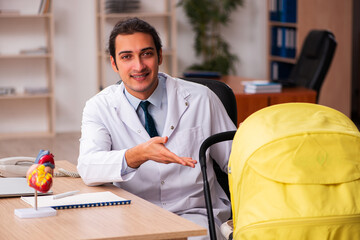 Young male doctor looking after new born in the clinic