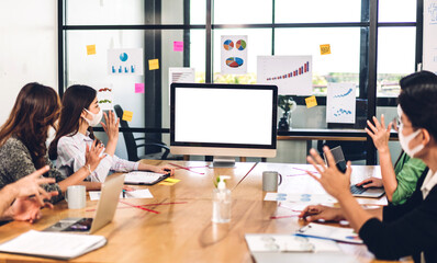 Group of professional asian business meeting and discussing strategy with new startup project.Creative business people planning with desktop computer with white mockup blank screens in modern office