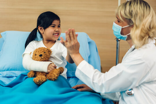 Woman Doctor Wearing Protective Mask Service Help Support Discussing And Consulting Talk To Little Girl Patient And Giving Hi Five Check Up Information In Hospital