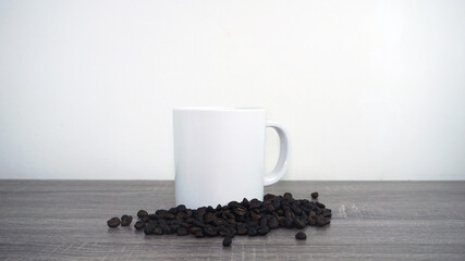 White cup and coffee beans on table in white background
