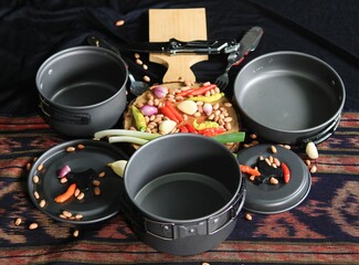 pans, knives, cooking utensils and kitchen ingredients such as chilies, shallots, garlic, ready to cook.
