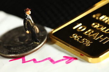 Miniature figure model of businessman and real gold bar represent business concept related idea.