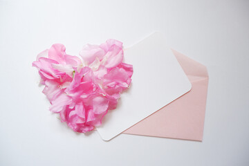 Heart made by Sweet pea flower petals with A blank greeting card. Spring and love concept background for Mother's day , wedding day and Spring greeting.スイートピー花びらのハートとカートセット、ハート型の花びら、母の日、春のイベント、結婚式、招待状