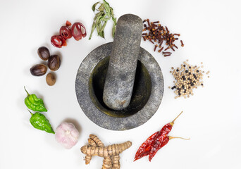 Sri Lankan Spices - Ginger, garlic chillies, Nutmeg, Mace, curry leaves, cloves, pepper with a mixture of grounded spices on a gal wangediya. A tool used to grind.