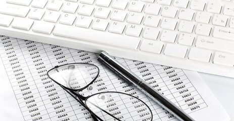 Obraz premium business work with chart,glasses, pen and keyboard on white office desk top view