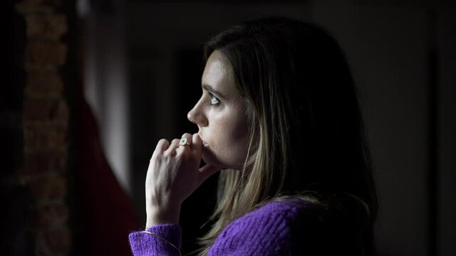 Young standing by window at home looking outside
