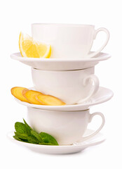 Creative layout made of cup of mint tea, lemon, ginger on a white background