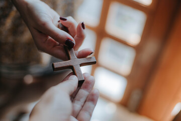 a wooden cross in woman hands.
