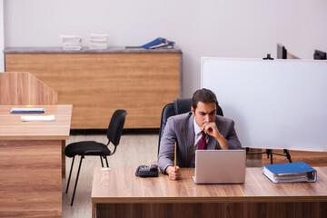Young male business trainer in the office during pandemic