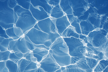 Blue water surface with bright sun light reflections, water in swimming pool