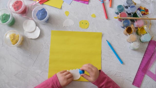 Child making card with Easter chick from colorful paper and cotton pad. Handmade. Project of children's creativity, handicrafts, crafts for kids. step 1