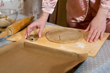 A woman in pink makes homemade shortbread cookies in the shape of hearts.