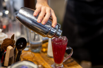 Fototapeta na wymiar The bartender pours fresh cocktails in a glass.