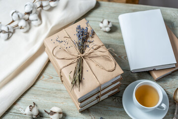 Neat, beautiful stack of books with craft paper covers, wrapped in rope and decorated with lavender...