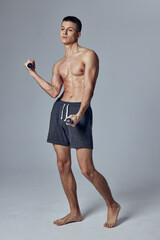Fototapeta premium sports man in shorts dumbbells in hands training gym 