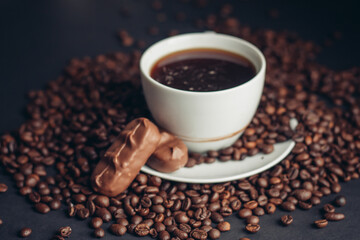 a cup of coffee and a chocolate bar on a saucer arabica beans variety drink