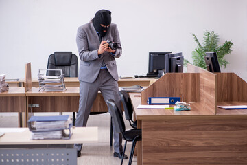 Young male employee in industrial espionage concept