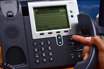 Hand of man using ip phone with flying icon of voip services and people connection, voip and telecommunication concept