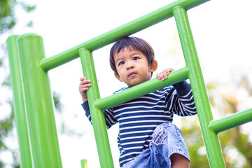 Faunny happy  3 year boy climbing on playground outdoor park