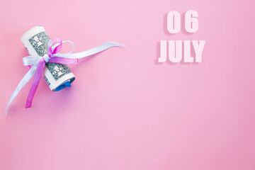 calendar date on pink background with rolled up dollar bills pinned by pink and blue ribbon with copy space. July 6 is the sixth day of the month