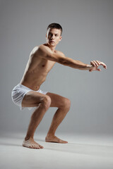 Obraz premium man doing sports Fitness squats with straightened arms