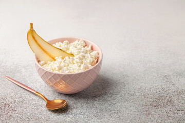 Healthy breakfast - cottage cheese with pear in a bowl on the table. Dairy product