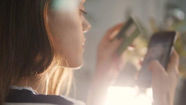 girl pays for purchases online shopping with a debit card in a smartphone. online store shop e-commerce concept. girl makes purchases in a web store with a internet debit card. online shopping