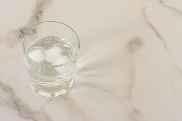 A glass of purified fresh drinking water on a marble table. copy space for text