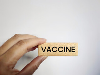 Social Issue Concept - VACCINE text on wooden block background. Stock photo.