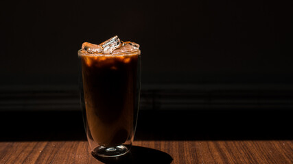 Close-up glass of iced coffee with milk on the table