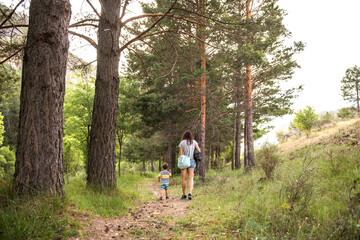 a mother walking with her son through the forest