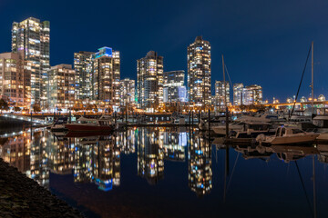 View of Vancouver downtown marina at night. Beautiful buildings skyline reflection on the water. Yaletown Dock. British Columbia, Canada.
