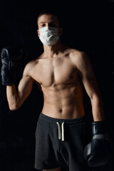 Fototapeta na wymiar athlete in medical mask and in boxing gloves on isolated background cropped view of bodybuilder 