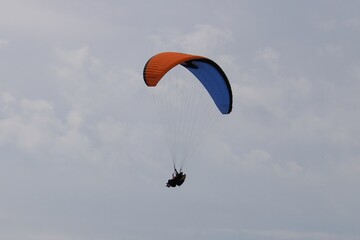 One paraglider is flying in the blue sky. Paragliding on a sunny day.