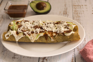 Traditional Mexican food, golden meat tacos (flautas) with red sauce.