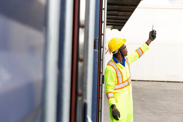 Foreman using mobile phone and laptop in the port of loading goods. Foreman on Forklifts in the Industrial Container Cargo freight ship.