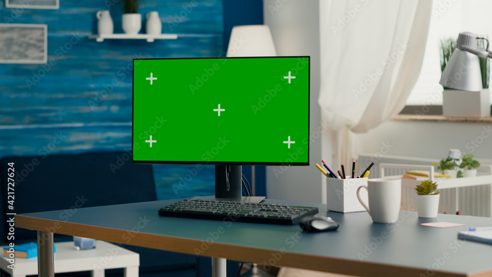 Poster desktop computer with mock-up green screen chroma key placed on desk in empty living room. pc with i