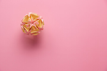 Multicolor handmade modular origami ball or Kusudama Isolated on pink background. Visual art,...